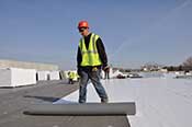 Single Ply Roof Membrane System - Step 2 - Apply membrane, overlapping seams in the direction of water run-off.